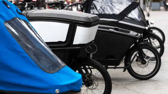 En rad med parkerade moderna lastcyklar.